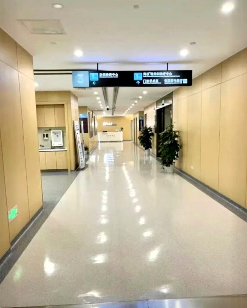 Hospital hallway with overhead directional sign.