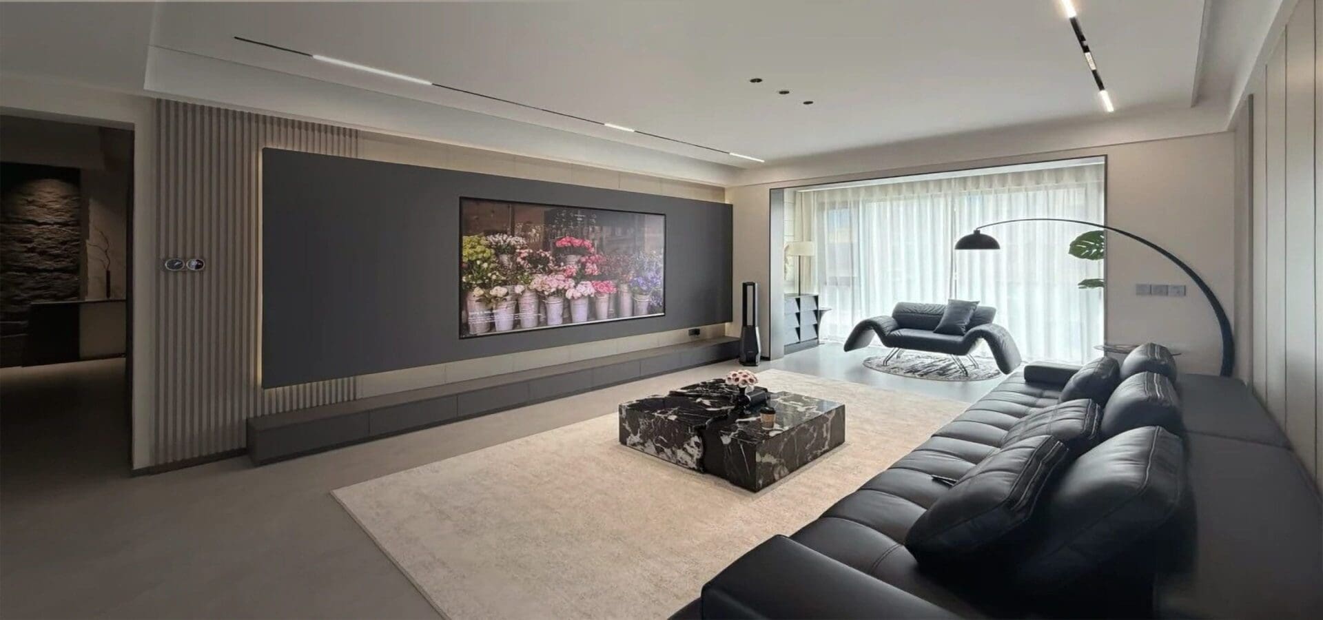 Modern living room with black leather sofa.