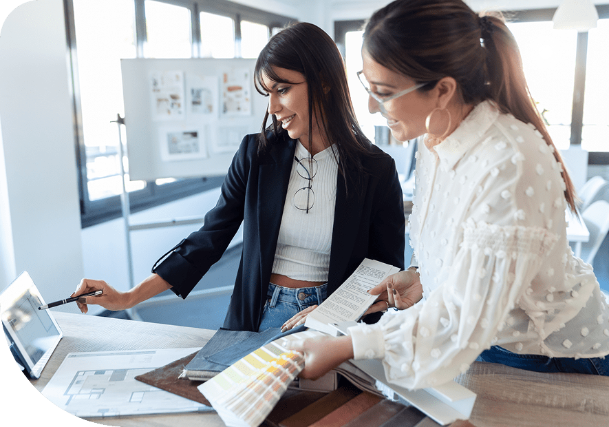 Two women reviewing color swatches and design plans together.